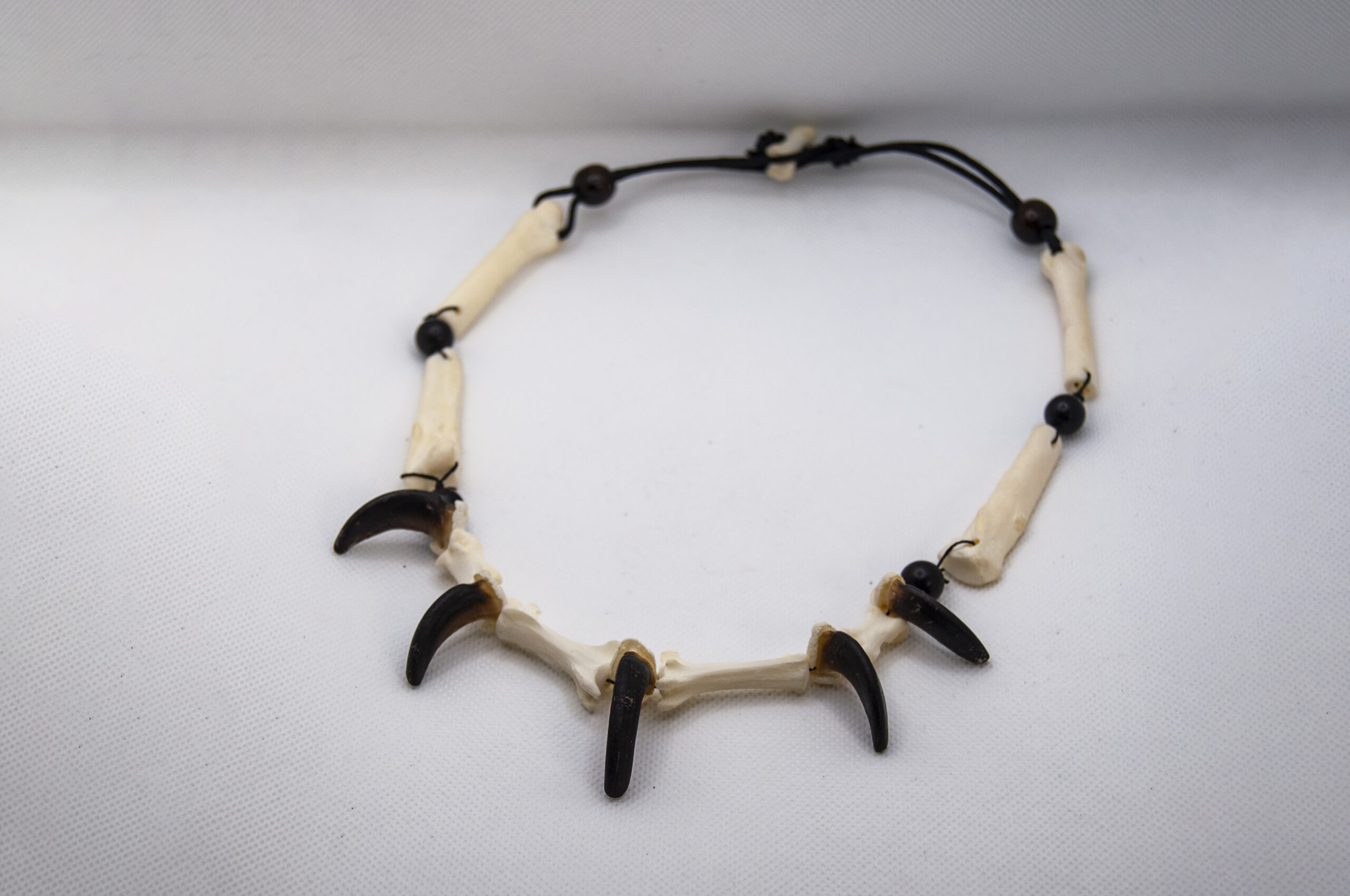 Collana con ossa metacarpali, falangi e artigli di lupo crisocione e perline in ebano
